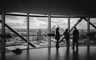 people standing at a window overlooking a city